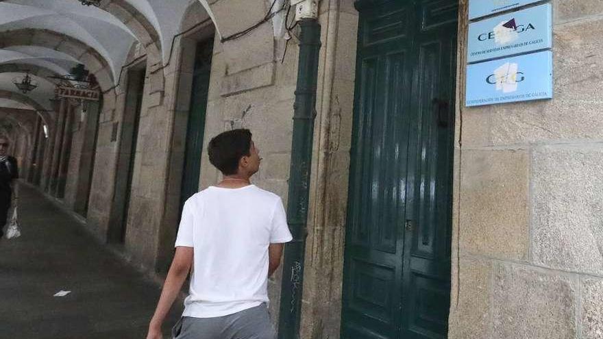 Un transeúnte, frente a la sede de la patronal gallega, ayer en Santiago.