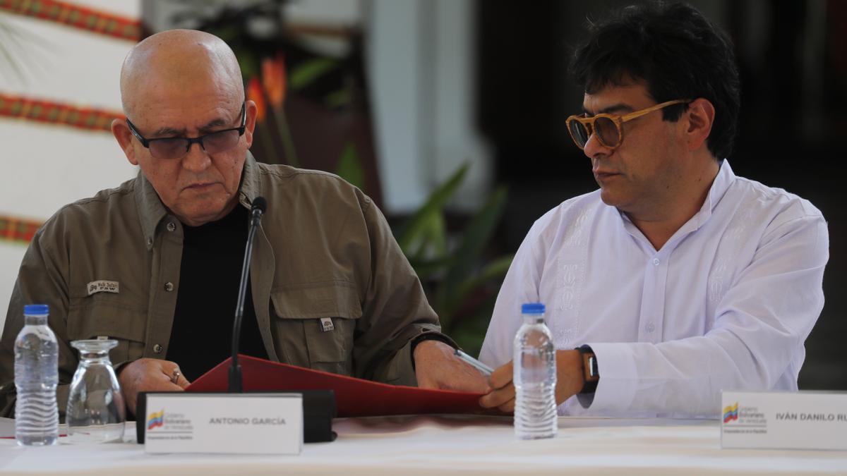 El portavoz del Ejército de Liberación Nacional Antonio García (i) y el del Gobierno de Colombia Iván Danilo Rueda (d) firman un acuerdo durante una reunión, en Caracas (Venezuela).