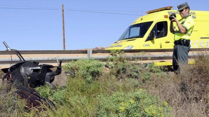 Un guardia civil saca fotos a la motocicleta del herido. i JAVIER FUENTES