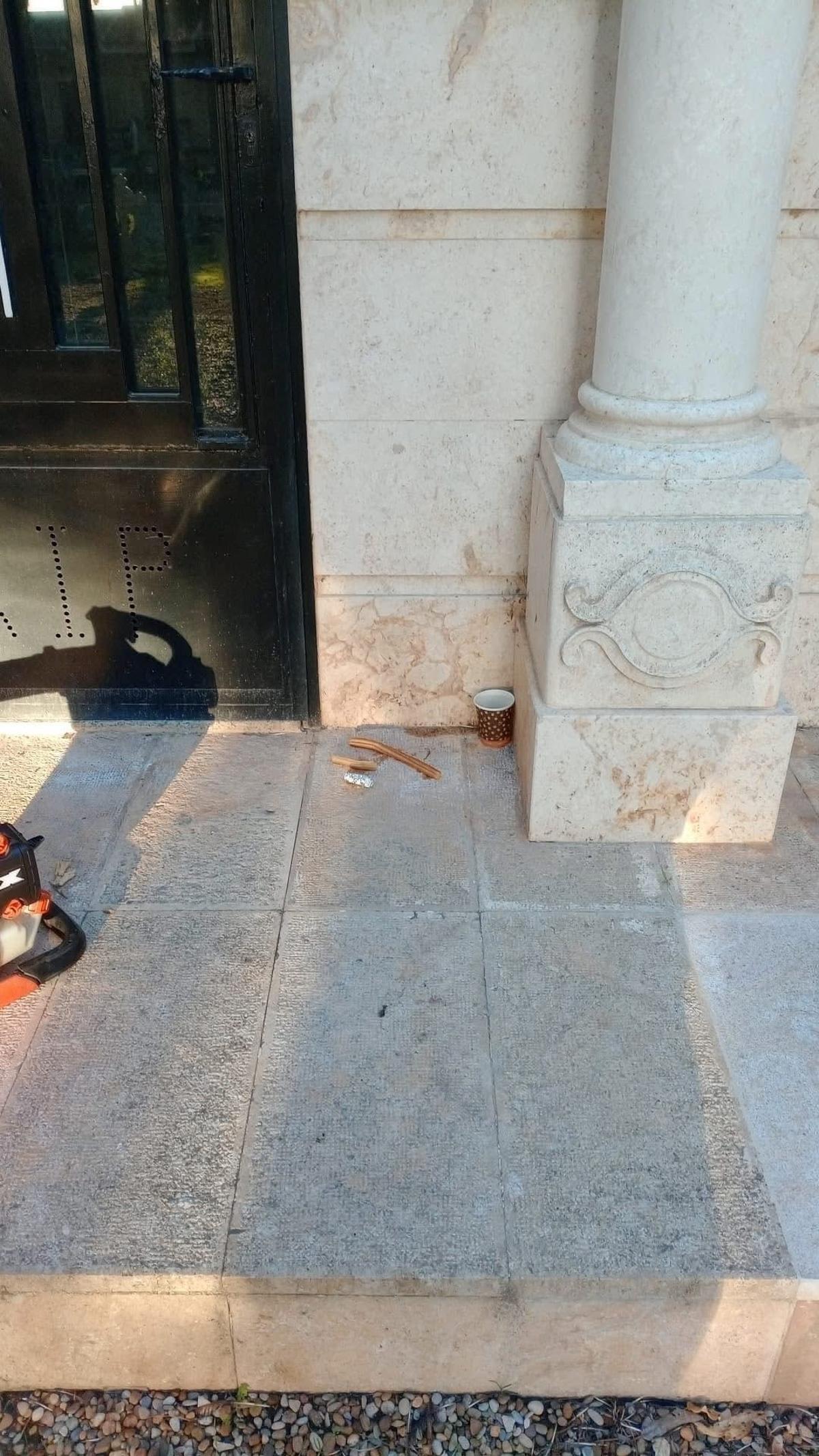 Restos de churros y un vaso de chocolate en el cementerio de Alagón (Zaragoza).