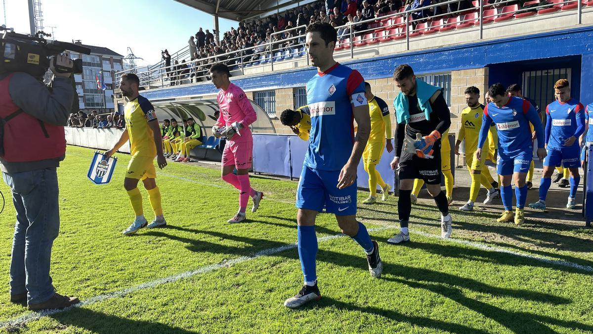 Los jugadores de ambos equipos saltan al impracticable terreno de juego de Urritxe.