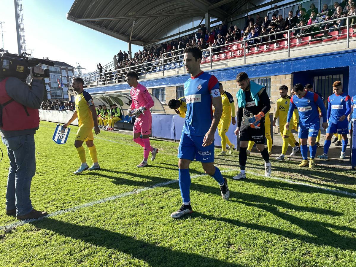 Los jugadores de ambos equipos saltan al impracticable terreno de juego de Urritxe.