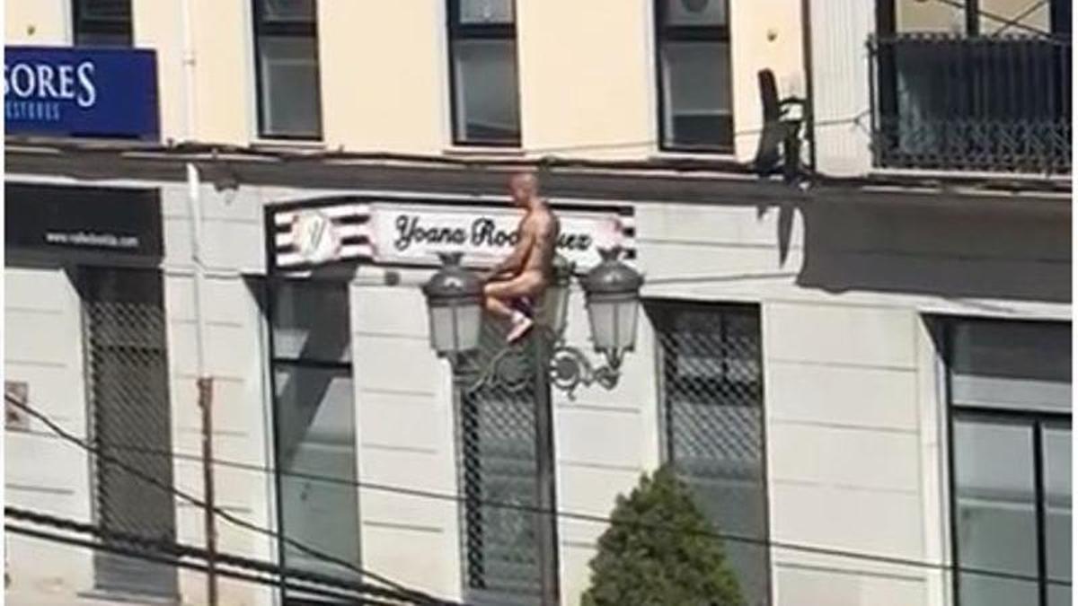 El hombre desnudo subido en la farola de la plaza de la Constitución de Elda.