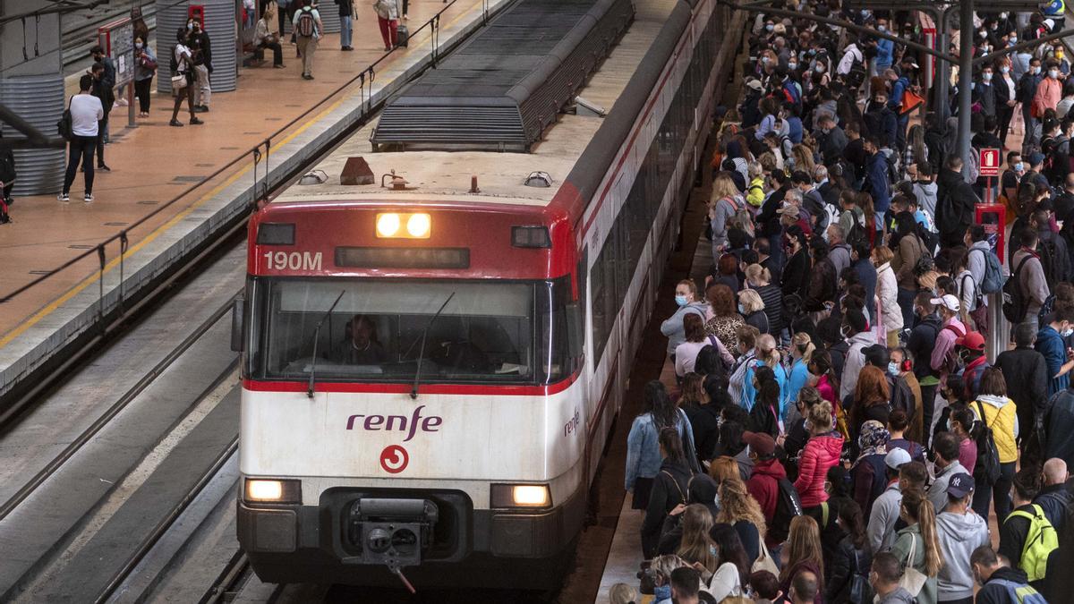 Decenas de personas esperan a un tren de cercanías en la estación de Atocha (Madrid)