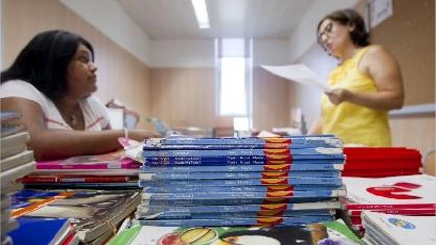 Mª Luz Abad (dcha.) atiende a una alumna que busca libros en el &quot;banco&quot; del IES Rascanya.