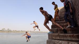 En la imagen de ayer, varios niños se lanzan al agua del Nilo para refrescarse, en Qanater, en las afueras de El Cairo. EFE/KHALED ELFIQI