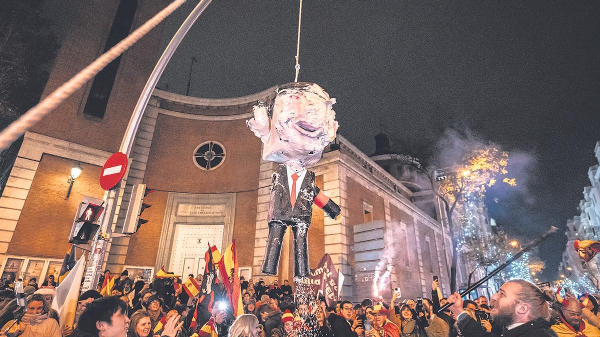 Manifestantes se concentran ante la sede del PSOE en Madrid y apalean un muñeco que representa a Pedro Sánchez
