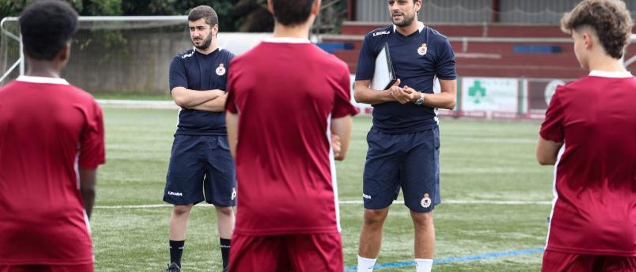 Míchel, en el centro, ayer en Santa Cruz, con Emilio Vázquez, delegado del cadete B del Gijón Industrial. | Juan Plaza