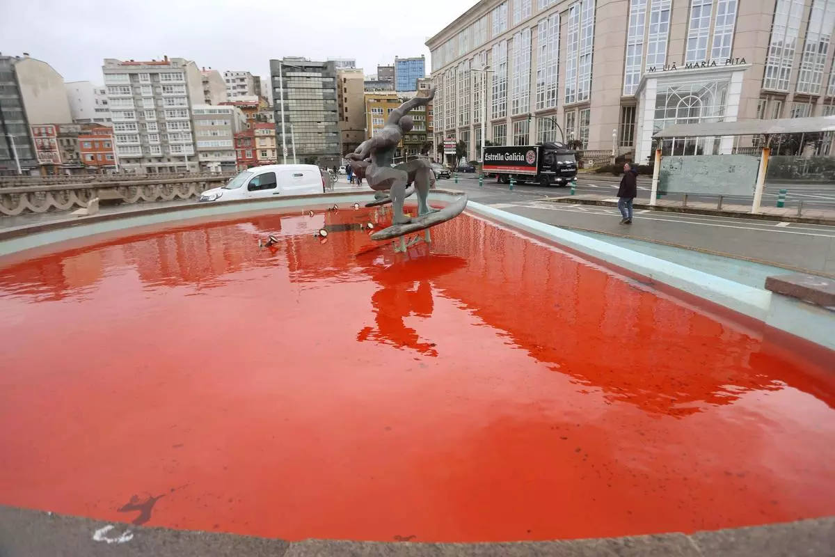 La fuente de los surfistas, con el agua teñida de rojo y una pintada contra Israel
