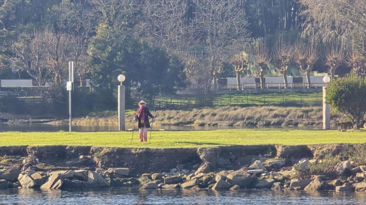 Una mujer disfrutando del entorno y el buen tiempo en la isla de A Toxa.