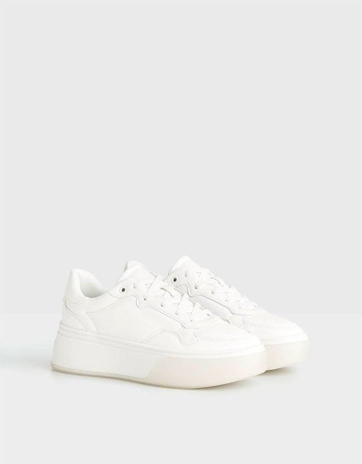 Zapatillas blancas con plataforma y suela translúcida de Bershka. (Precio: 25,99 euros)