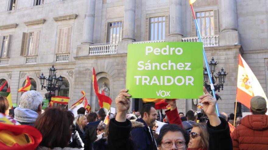 Una dona amb una pancarta de Vox on es llegeix &#039;Pedro Sánchez, traïdor&#039; davant la façana de l&#039;Ajuntament de Barcelona