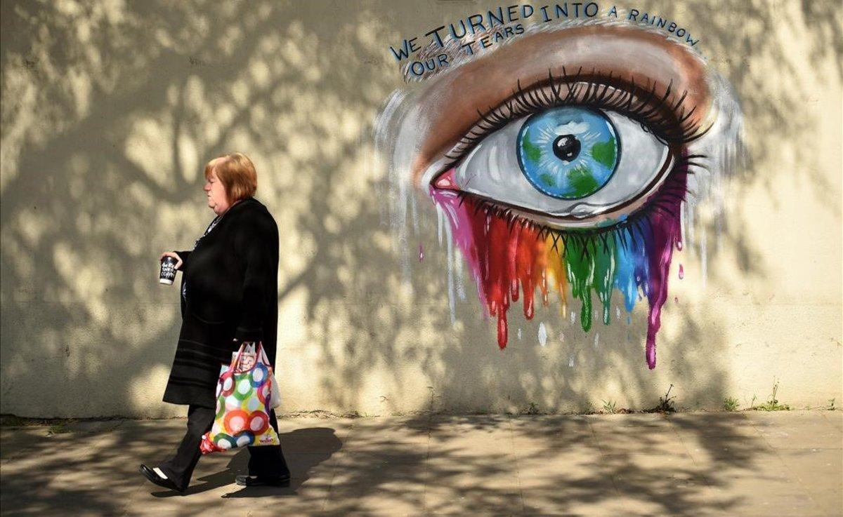 Una mujer pasa frente a un mural de la artista callejera Rachel List en la localidad inglesa de Pontefract.