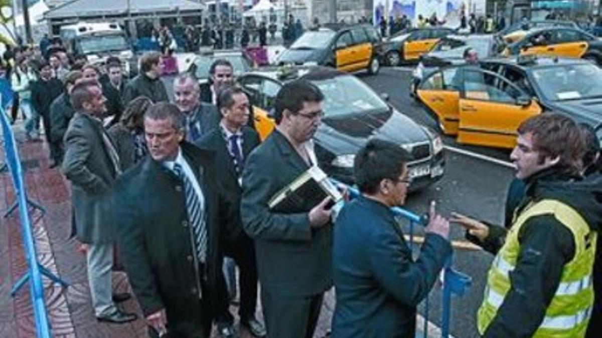 Colas de asistentes al congreso para coger un taxi, ayer, en la parada instalada en la plaza de Espanya.