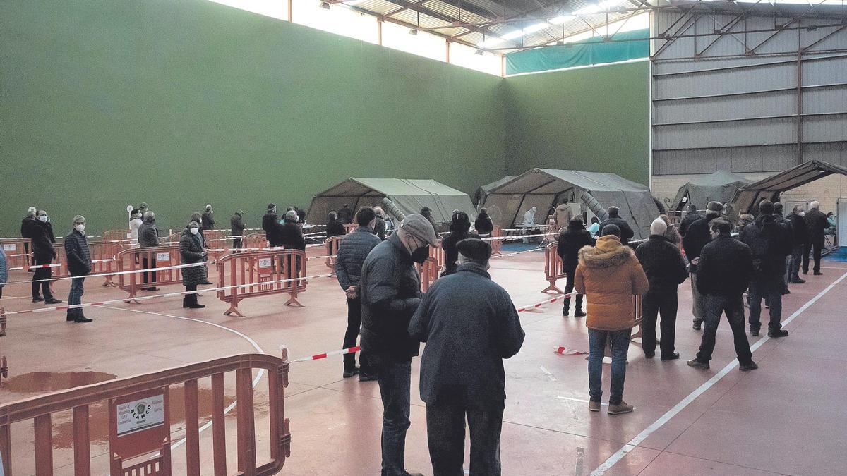 Colas en el interior del pabellón de Monfarracinos de personas que participan en el cribado con tests de antígenos. | Jose Luis Fernández
