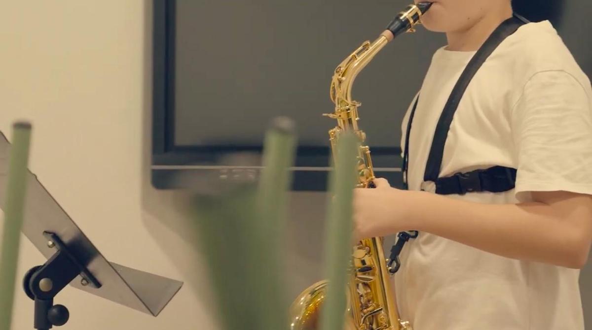 Un xiquet tocant el saxofon.