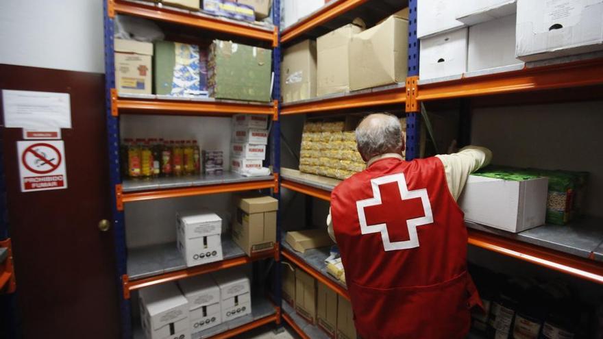 Personal de Cruz Roja España recoge comida de sus fondos.