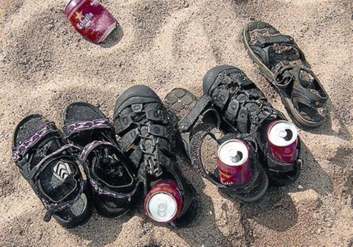Unes llaunes de cervesa dins d’unes sandàlies, a la Barceloneta. Unes llaunes de cervesa dins d’unes sandàlies, a la Barceloneta.