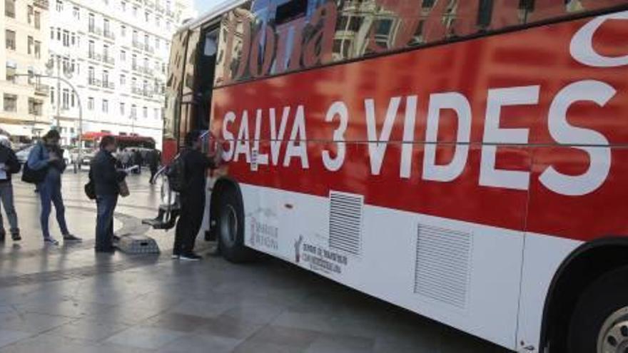 Varias personas hacen cola a la puerta del autobús para hacerse donante de médula.