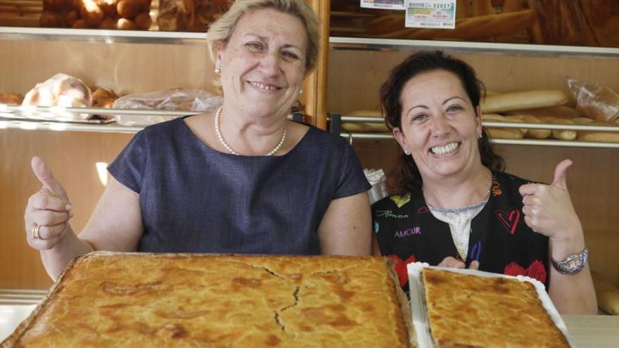 Rosa Pérez posa con una de sus empleadas y la coca amb tonyina que elaboran.