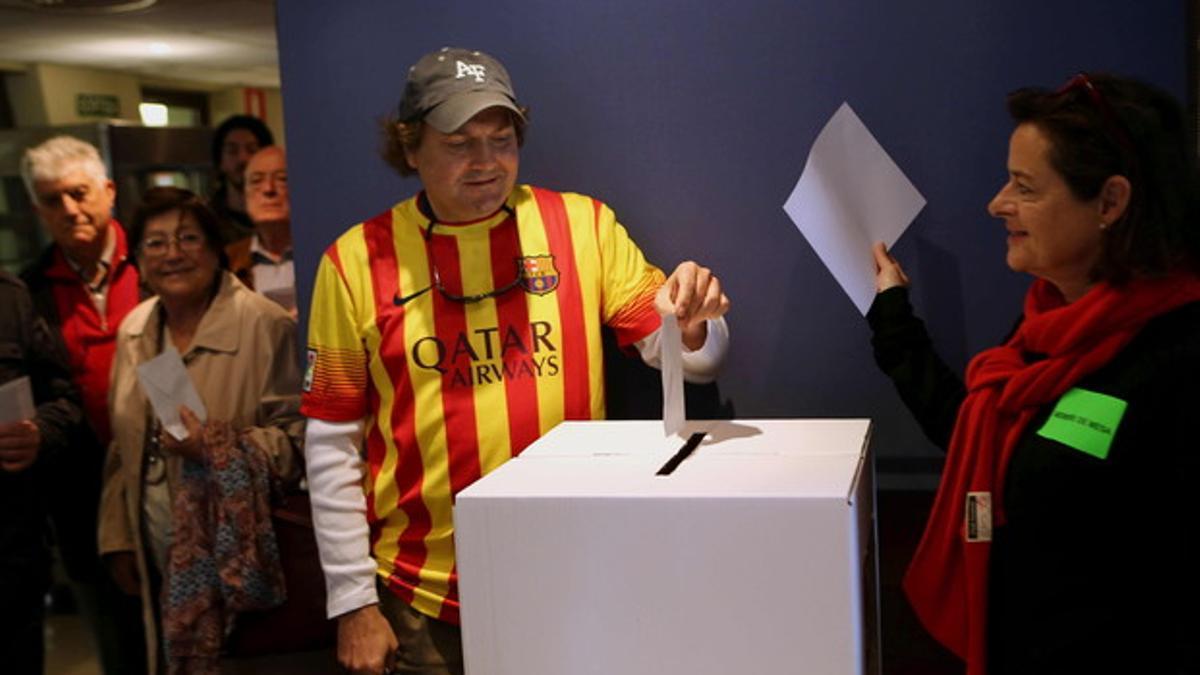 Un ciudadano deposita su voto, en un punto de participación en la Via Augusta de Barcelona.