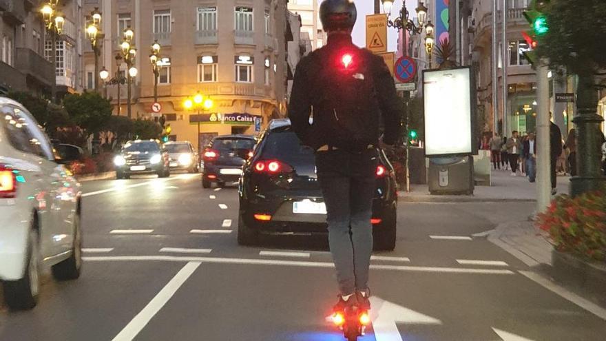 Un usuario de patinete eléctrico circulando con alumbrado por Urzáiz.