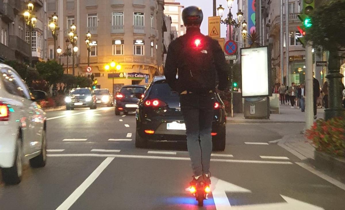 Un usuario de patinete eléctrico circulando con alumbrado por Urzáiz.