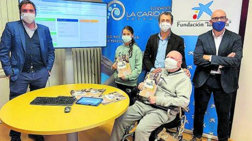 Responsables de CaixaBank y La Caridad, junto a dos usuarios. | SERVICIO ESPECIAL