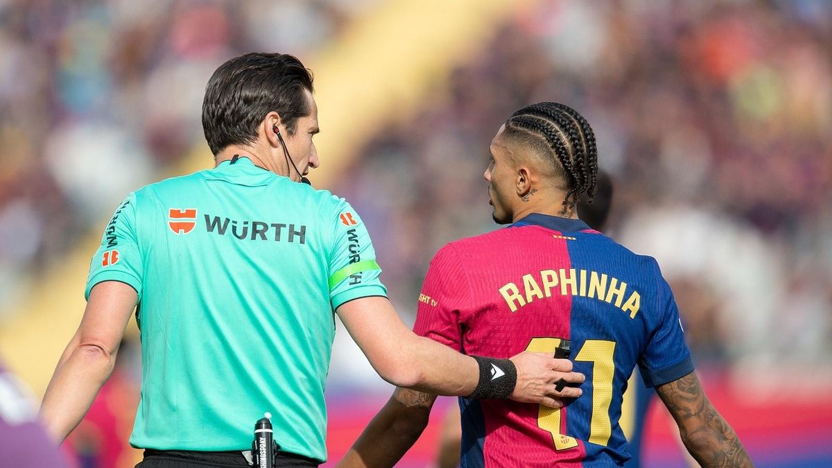 Munuera Montero habla con Raphinha durante el partido.