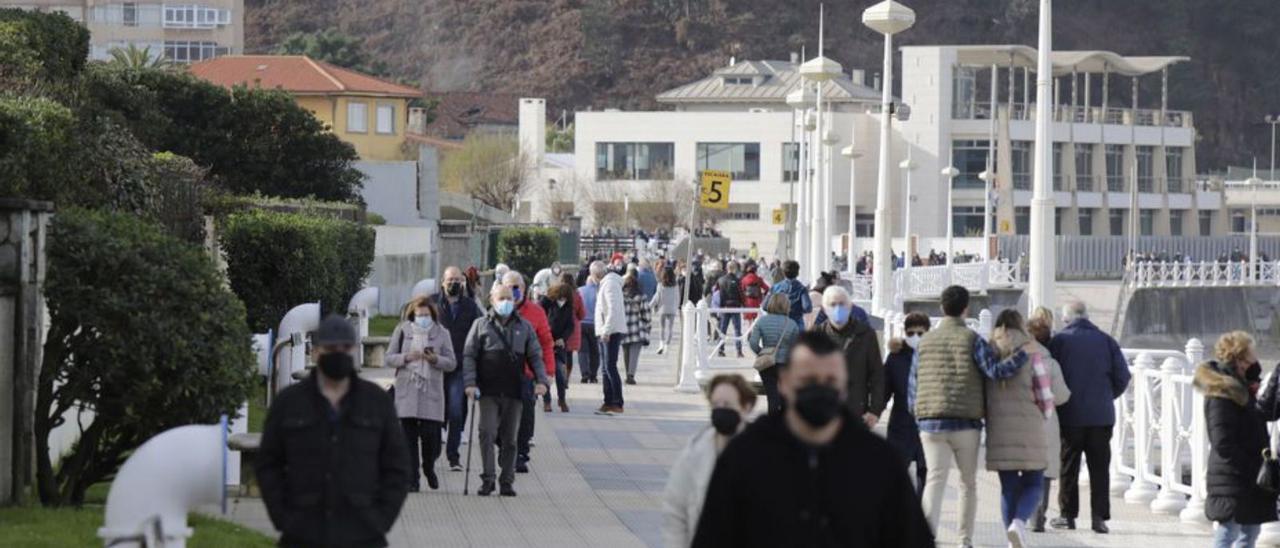 Paseantes en Salinas, con el Club Náutico al fondo. | F. Rodríguez