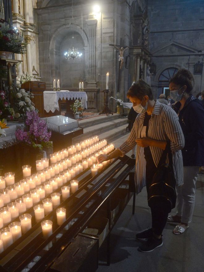 Una mujer enciende velas en el templo.