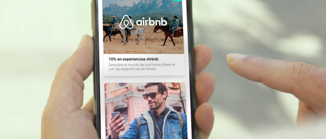 Un Joven consulta la aplicación Airbnb