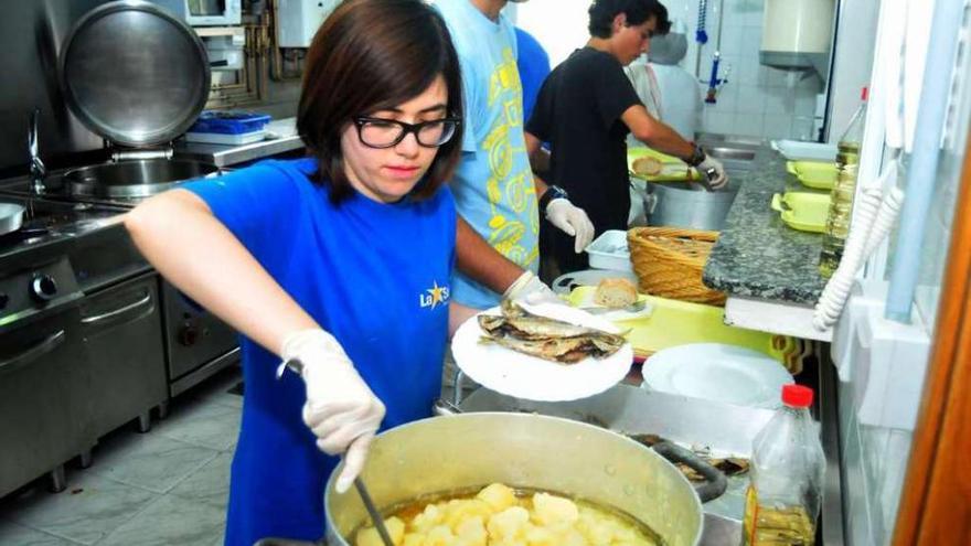 Una universitaria de Gijón reparte la comida para los usuarios de Cáritas.