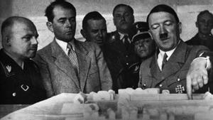 Hitler muestra una maqueta a varios hombres, entre los que se encuentran militares nazis.
