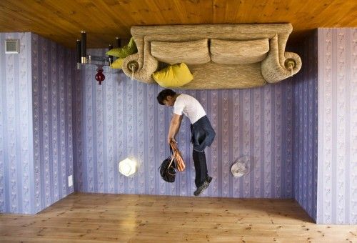 A tourist jumps inside an upside-down house at Fengjing Ancient Town