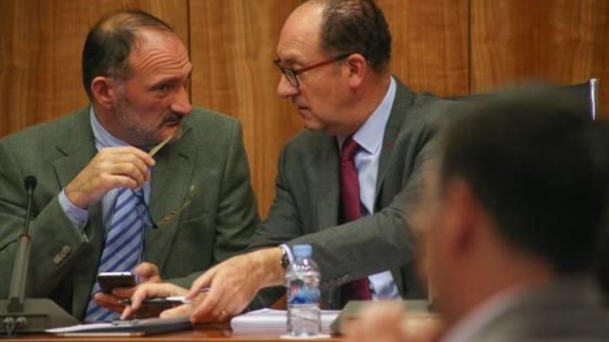 El concejal Rafael Almagro y el regidor, Emilio Bascuñana, hablan durante un pleno.