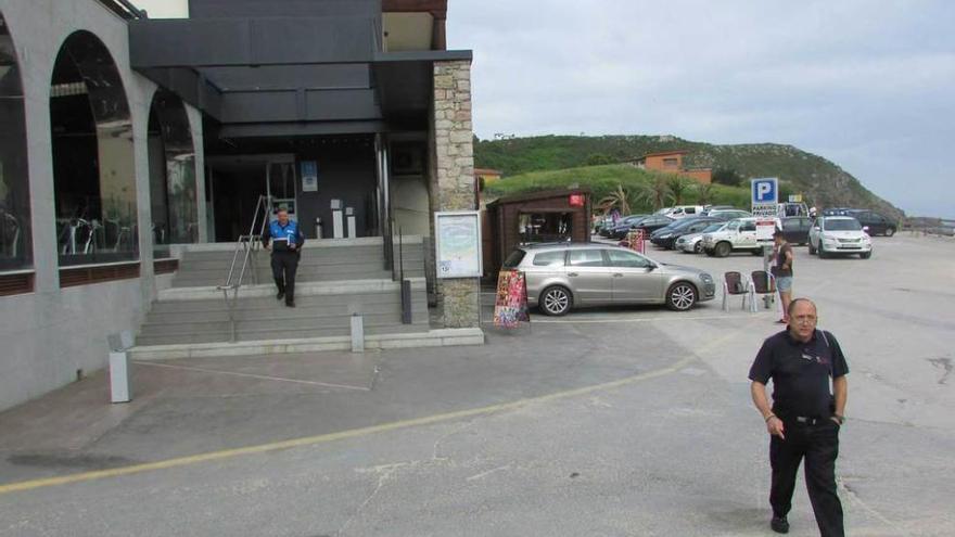 El vigilante urbanístico -en primer término- y el sargento de la Policía de Llanes, ayer, saliendo del hotel Kaype, tras proceder al precinto de las instalaciones construidas al amparo de dos licencias anuladas por los jueces.