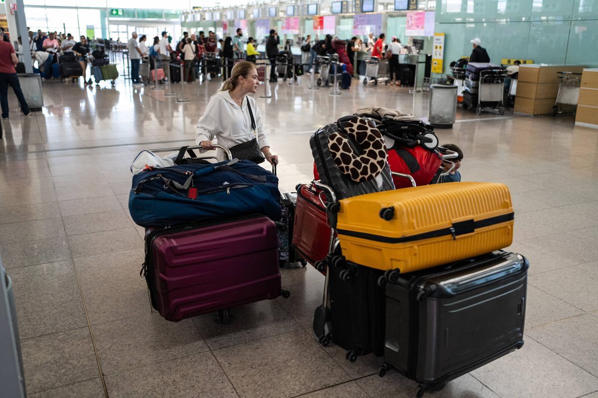 Mujer en el aeropuerto con varias maletas.