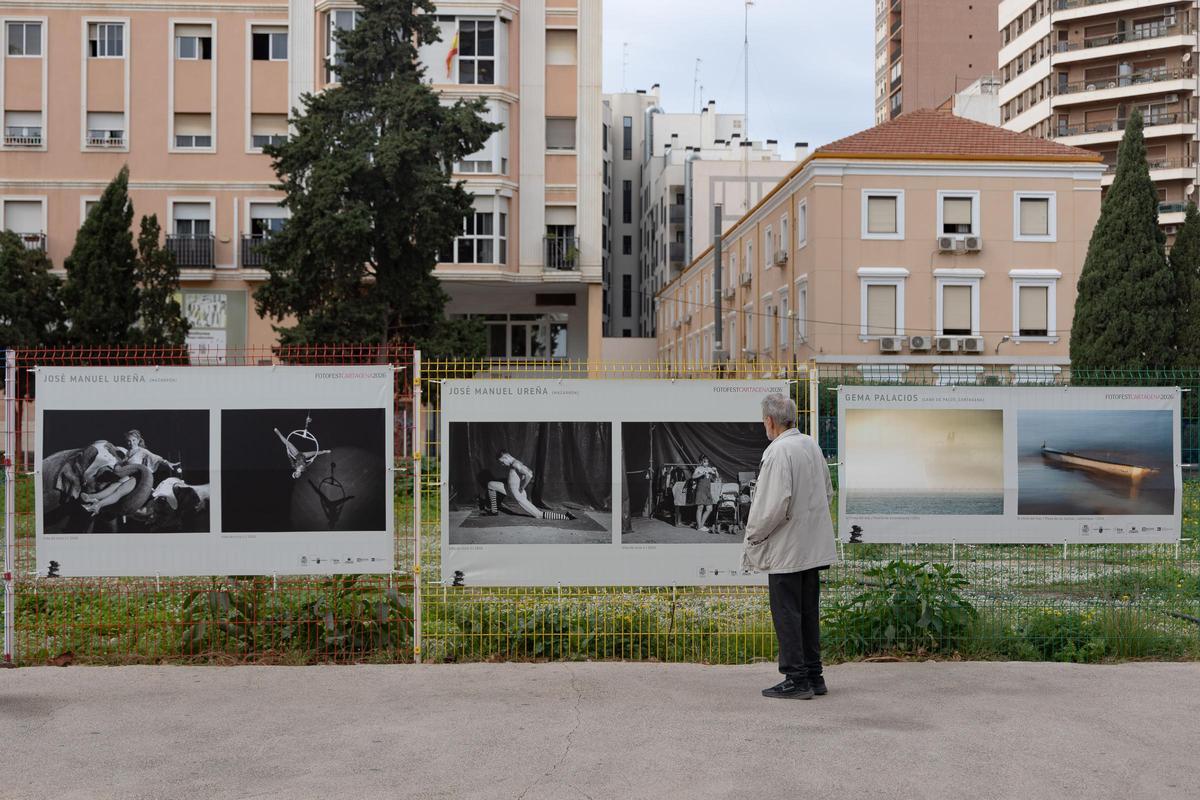 Un viandante observa algunas de las fotografías expuestas en la calle.