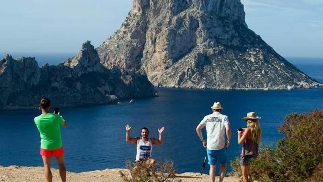 Unos turistas, frente al islote de es Vedrà.