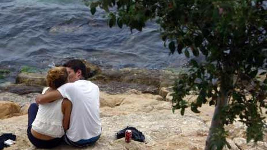 Una pareja se besa en una cala de Alicante.