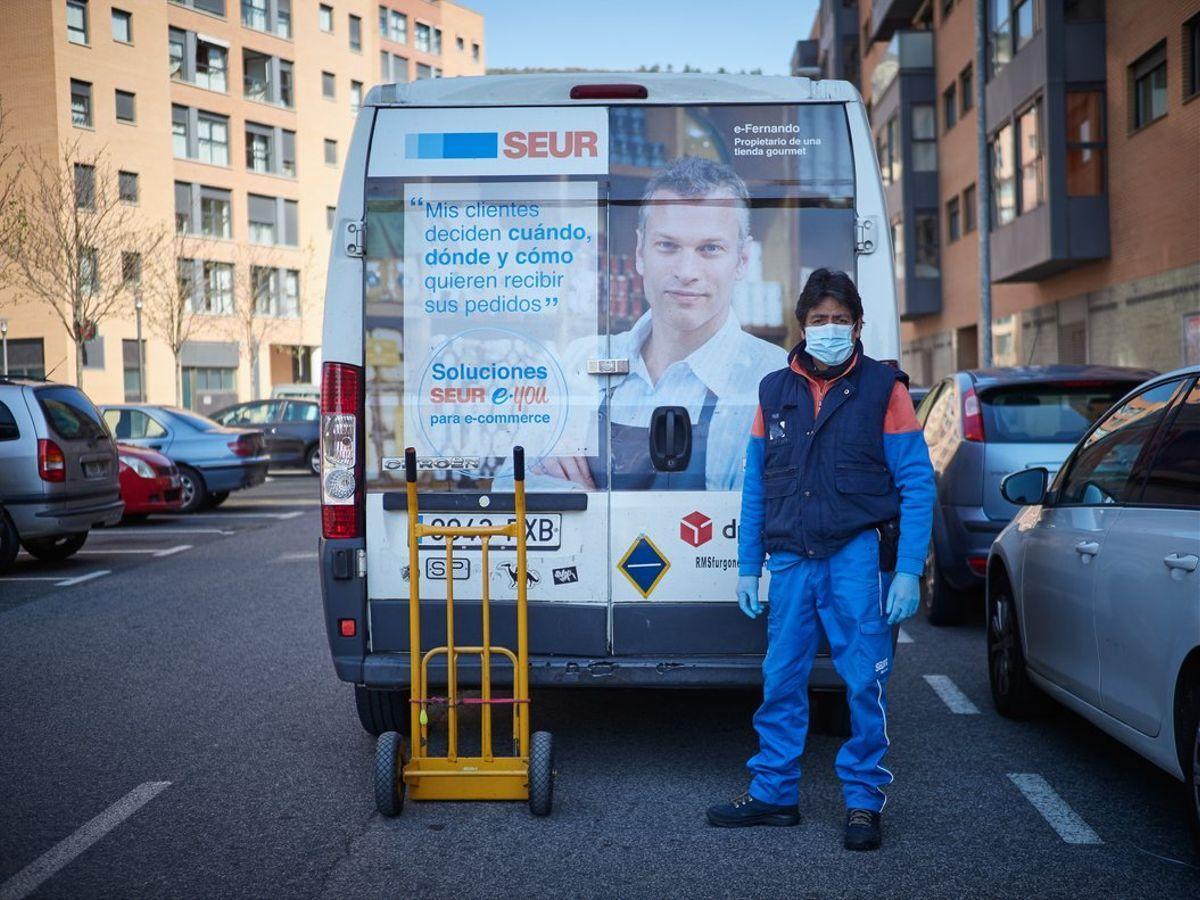 Un repartidor autónomo de Seur frente a una furgoneta.