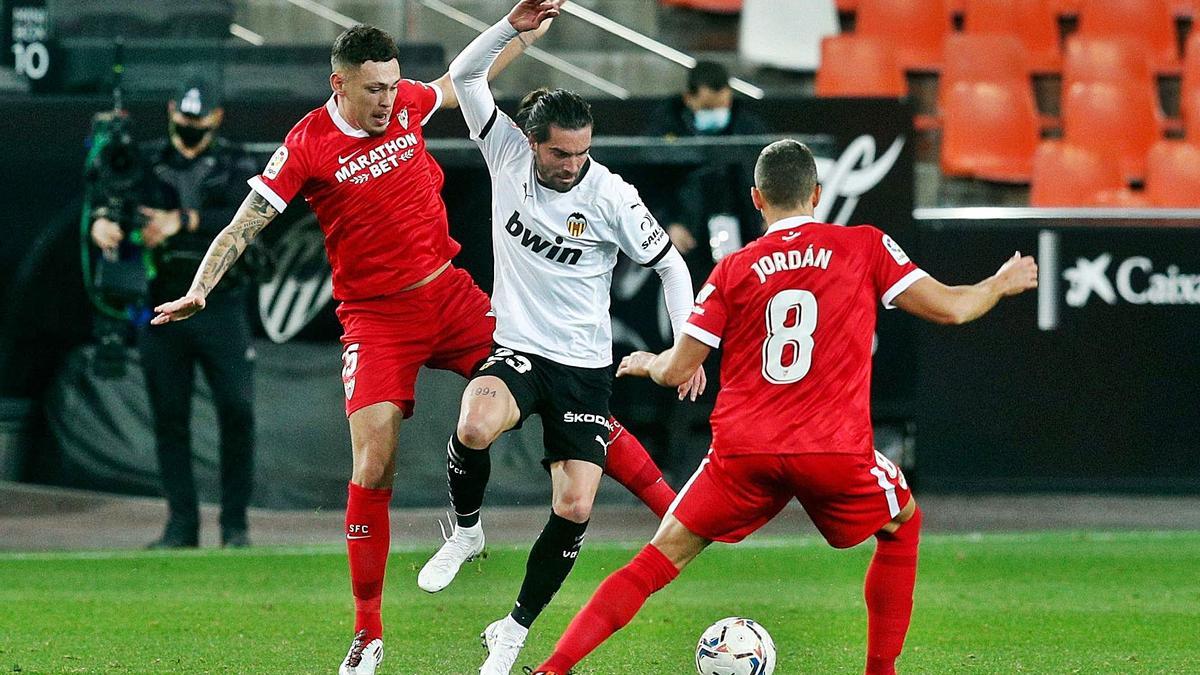 Jason intenta controlar la pelota entre dos futbolistas del Sevilla, el martes pasado en Mestalla.  | EFE/KAI FÖRSTERLING