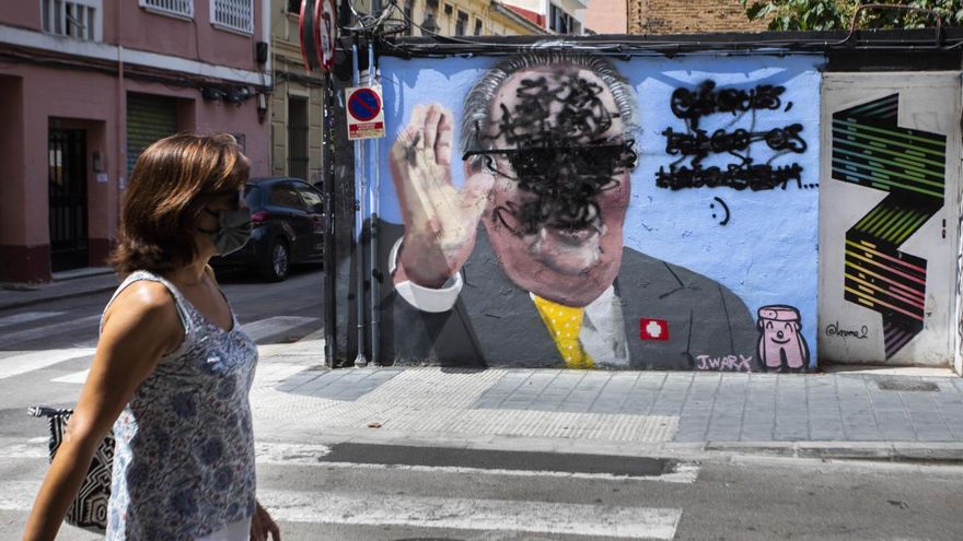 Un encapuchado tacha el mural satírico de Juan Carlos I en Benimaclet.