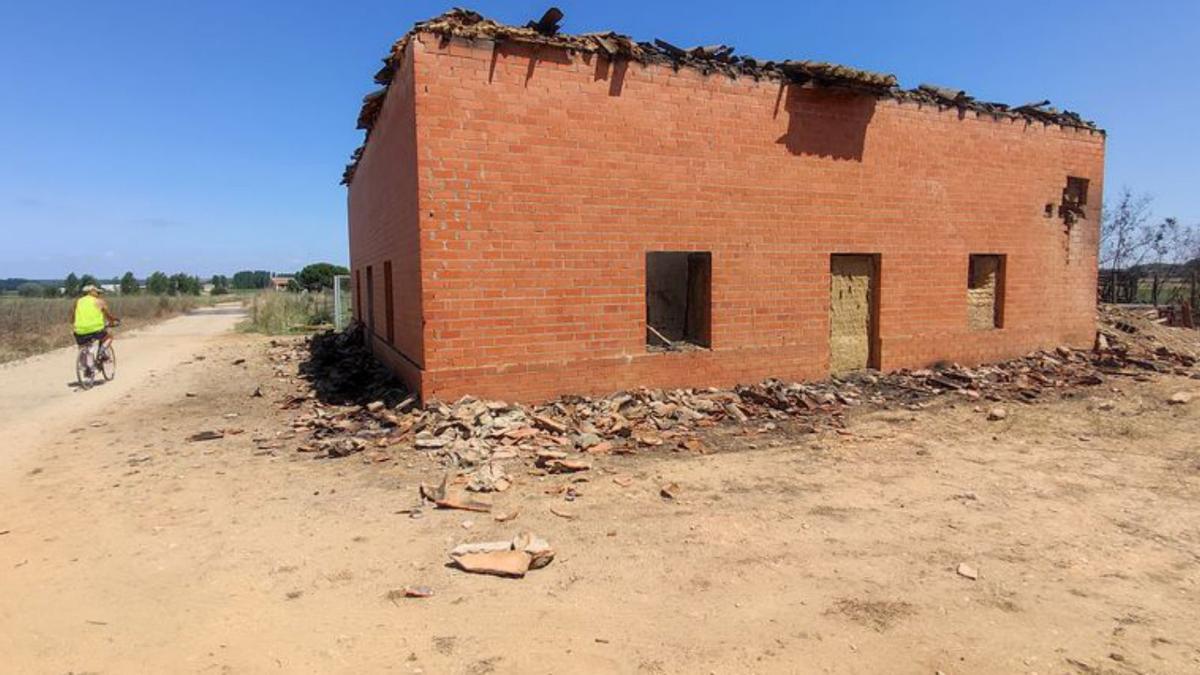  Un ciclista observa un edificio quemado en Santa Croya.