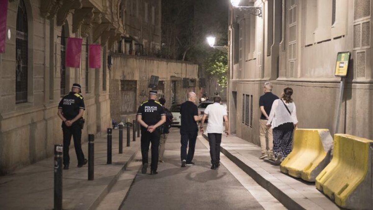 Una pareja de agentes de la Guardia Urbana patrullan de noche