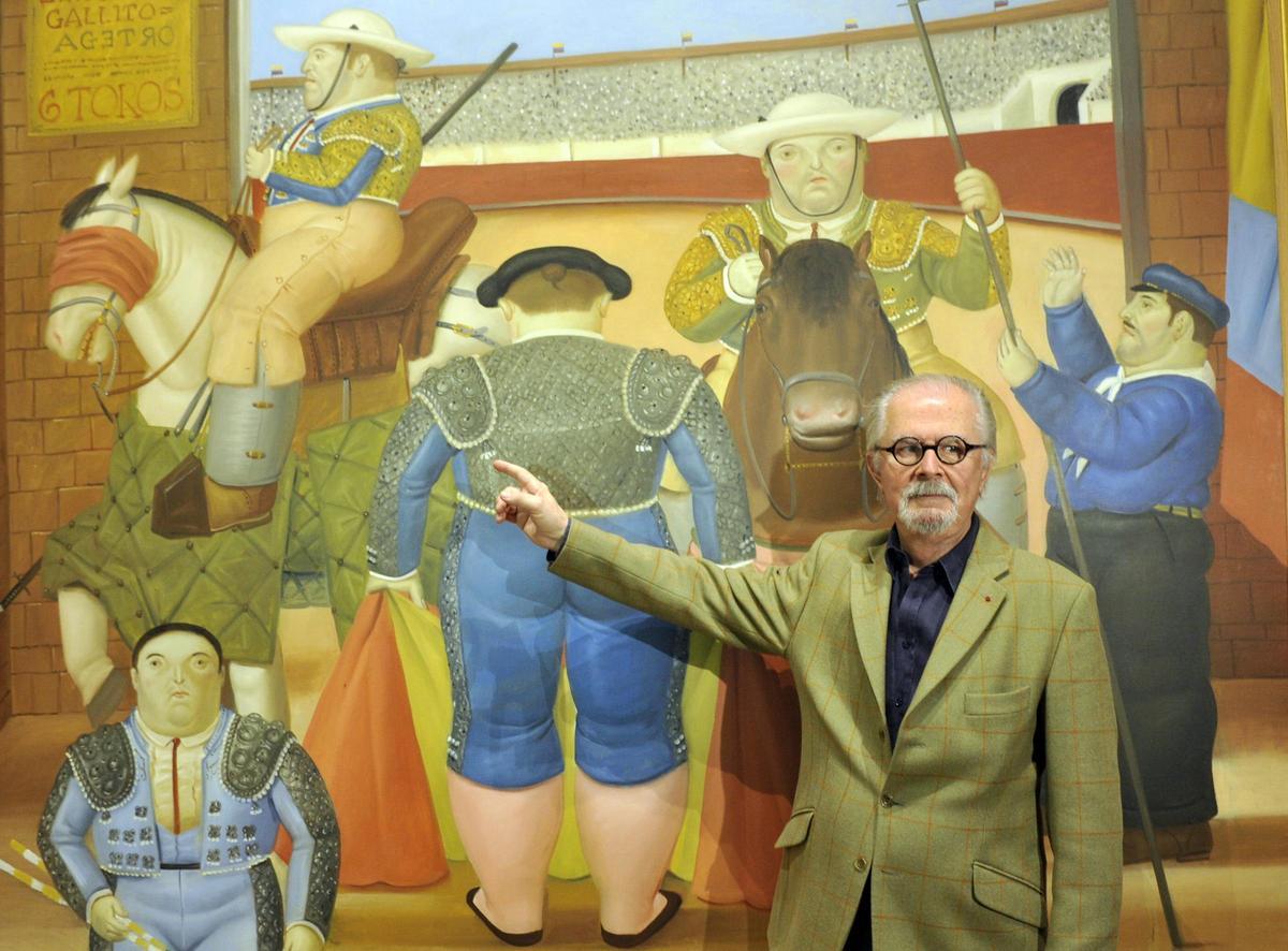 El escultor y pintor colombiano Fernando Botero posa en 2012, frente a una de las obras durante una exposición en México.