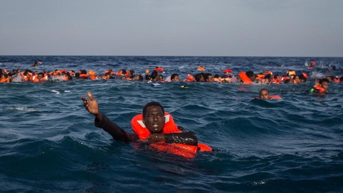 Refugiados e inmigrantes nadan y piden ayuda cerca de Lampedusa, el pasado mayo.