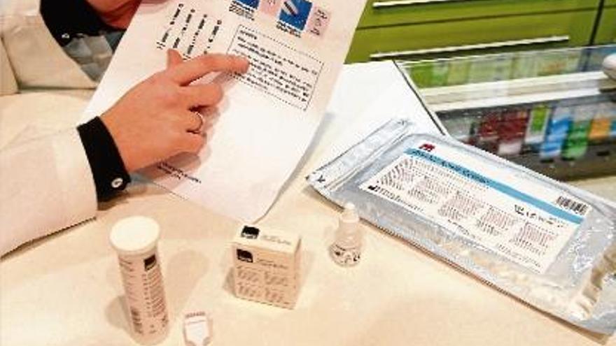 Una farmacèutica de Girona mostra els elements del test de detecció precoç del VIH.