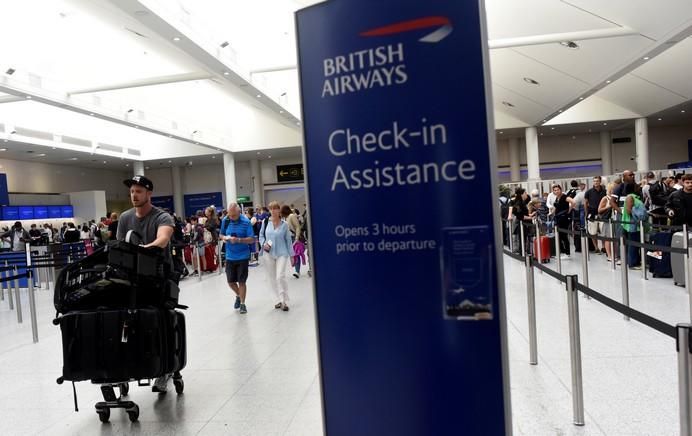 People arrive for the British Airways check-in ...